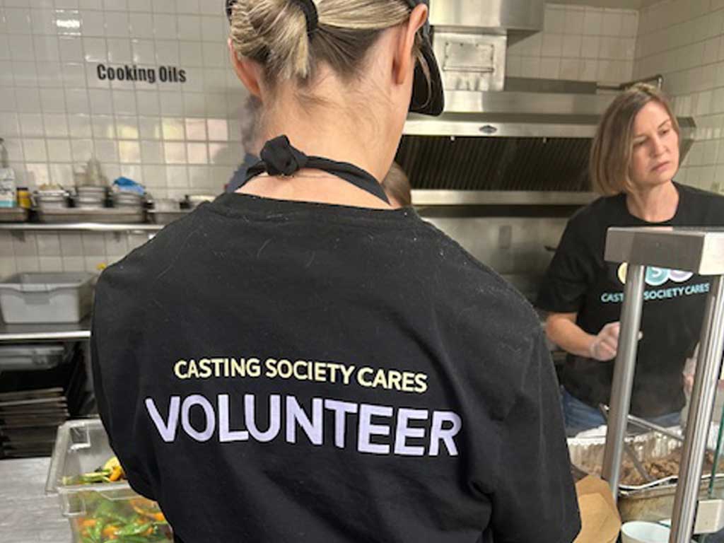 Woman volunteer with Casting Society Cares written on the back of her shirt